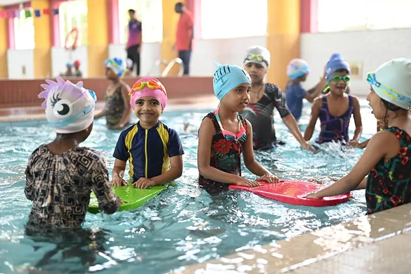 Young swimmers with kickboards in the school's indoor pool